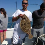 Man wearing sunglasses with flounder aboard the Judith M charter boat