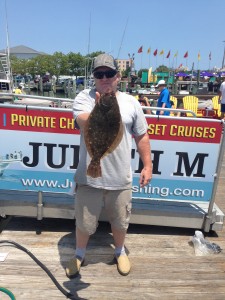 Older man holding brown flounder on Ocean City's fishing dock