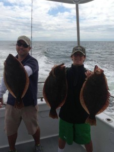 A man and boy with their flounder on the Judith M fishing boat