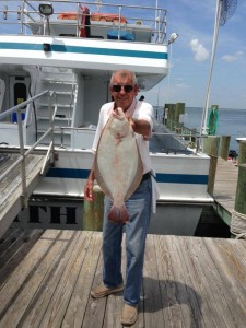 Older man standing on Ocean city fishing dock with flounder