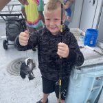 Picture of boy holding rod and fish.